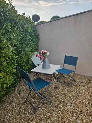 two chairs and a table with a vase of flowers at AUPETIT BONHEUR in Lauris