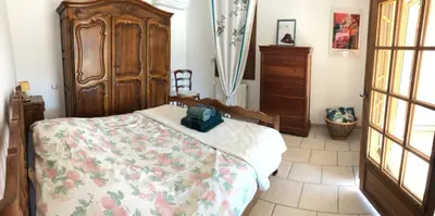 a bedroom with a bed and a wooden dresser at La maison des Sources in Salon-de-Provence