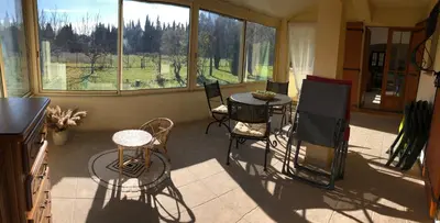 a screened in porch with a table and chairs at La maison des Sources in Salon-de-Provence