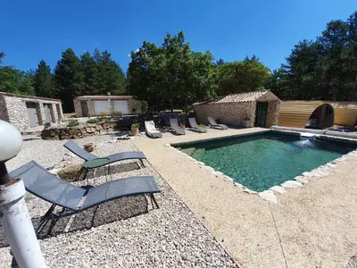 a backyard with a pool with lounge chairs and a swimming pool at Gîte Le Refuge in Monieux