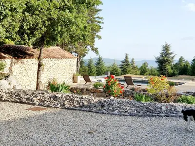 a cat standing in front of a rock garden at Gîte Le Refuge in Monieux