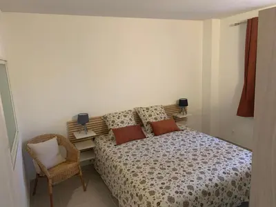 a bedroom with a bed and a chair at la pinède in Roussillon