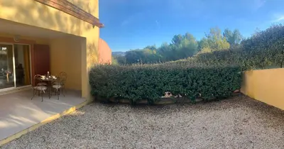 a patio with a hedge on the side of a building at la pinède in Roussillon