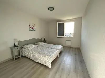 a white bedroom with a bed and a window at maison village vacances demeures du Ventoux in Aubignan