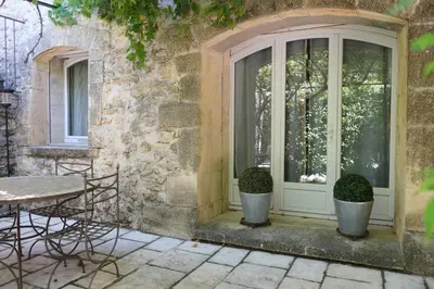 a patio with a door and a table and chairs at charming provencal house with private pool for 4 people in cheval blanc, luberon. in Cheval-Blanc