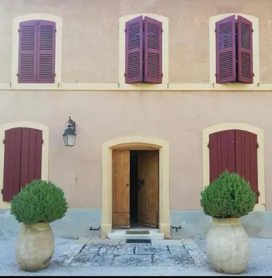 a building with pink doors and purple shutters at Suite le Quervalat dans magnifique bastide 18eme in Aix-en-Provence