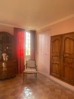 a room with a chair and a dresser and a window at Suite le Quervalat dans magnifique bastide 18eme in Aix-en-Provence