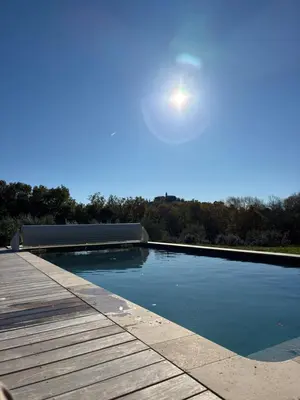 a swimming pool with a wooden deck and the sky at Villa des Mattes - Superbe maison de famille 15 couchages in Crillon-le-Brave