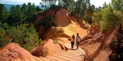 a man and a woman walking down a wooden path at Le Mazet de l'Isle sur la Sorgue in Saumane-de-Vaucluse