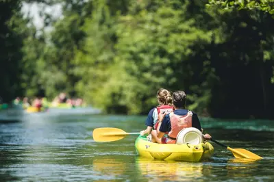 a man and a woman in a kayak on a river at Le Mazet de l'Isle sur la Sorgue in Saumane-de-Vaucluse