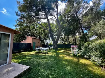 a backyard with a table and chairs and a tree at Aix-en-Provence, Maison provençale au calme de la campagne avec Jacuzzi in Aix-en-Provence