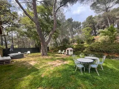 a table and chairs in a yard with a tree at Aix-en-Provence, Maison provençale au calme de la campagne avec Jacuzzi in Aix-en-Provence