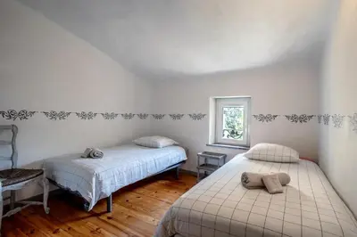 a bedroom with two beds and a window at La maison du château in Fontaine-de-Vaucluse