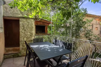 a table and chairs on the balcony of a house at La maison du château in Fontaine-de-Vaucluse