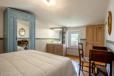 a bedroom with a bed and a desk and a sink at La maison du château in Fontaine-de-Vaucluse