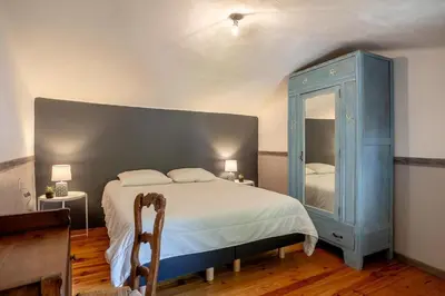 a bedroom with a bed and a blue cabinet at La maison du château in Fontaine-de-Vaucluse