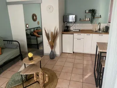 a kitchen with a table and two stools at Aix-en-Provence, Charmant studio proche toutes comodités et axes routiers, linges fournis in Aix-en-Provence