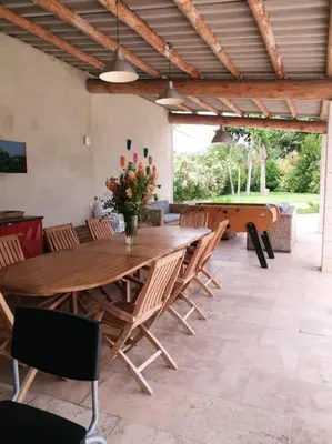 a large wooden table and chairs in a patio at Maison de 6 chambres avec piscine privée, jardin aménagé et wifi à Pernes-les-Fontaines in Pernes-les-Fontaines