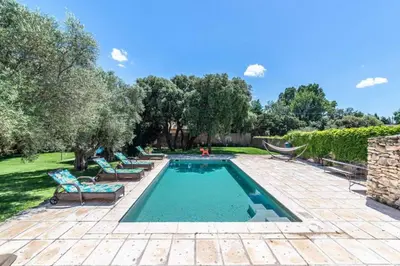 a swimming pool in a yard with chairs and trees at magnificent individual villa with heated swimming pool, in aureille, in the alpilles - 10 persons in Aureille