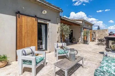 a patio with chairs and a table and a grill at magnificent individual villa with heated swimming pool, in aureille, in the alpilles - 10 persons in Aureille