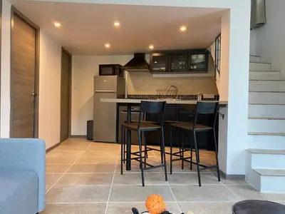 a kitchen with a counter and stools in a room at Gîte Le Tramontane Meublé de tourisme 4 étoiles Le Moulin de Prédelles in Reillanne
