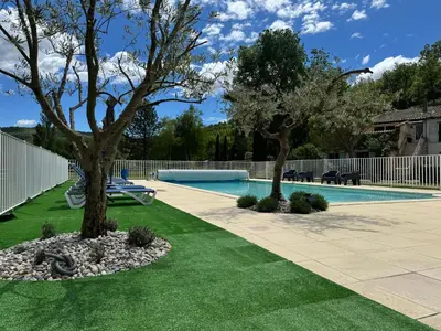 a swimming pool with two trees in a yard at Gîte Le Tramontane Meublé de tourisme 4 étoiles Le Moulin de Prédelles in Reillanne