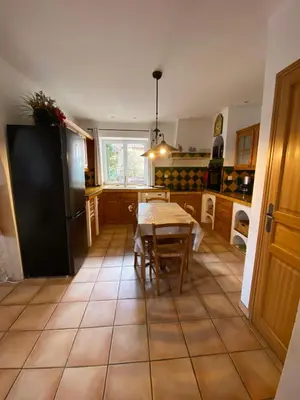 a kitchen with a table and a refrigerator at Gîte Le Sirocco Meublé de tourisme 4 étoiles Le Moulin de Prédelles in Reillanne