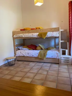 a bedroom with two bunk beds and a tiled floor at Gîte Le Sirocco Meublé de tourisme 4 étoiles Le Moulin de Prédelles in Reillanne