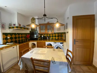 a kitchen with a table and chairs and a kitchen with a stove at Gîte Le Sirocco Meublé de tourisme 4 étoiles Le Moulin de Prédelles in Reillanne