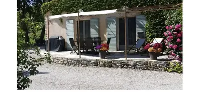 a house with chairs and flowers on a patio at Gîte Le Sirocco Meublé de tourisme 4 étoiles Le Moulin de Prédelles in Reillanne