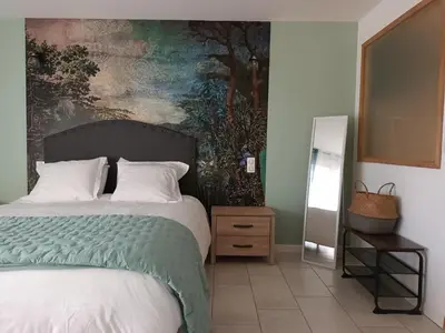 a bedroom with a bed with a painting on the wall at BASTIDE DES MARTELIERES in Salon-de-Provence