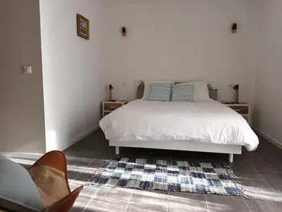 a bedroom with a white bed and a rug at BASTIDE DES MARTELIERES in Salon-de-Provence