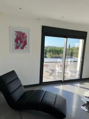 a black leather chair in a room with a sliding glass door at Villa Design in Bédoin