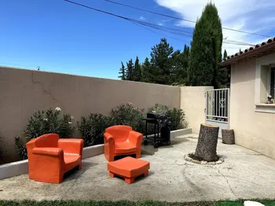 a group of orange chairs and a piano in a backyard at Les Lauriers en Lubéron in Cheval-Blanc
