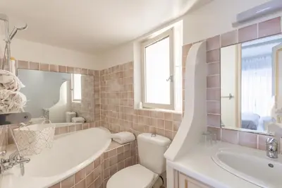 a bathroom with a tub and a toilet and a sink at Les Lauriers en Lubéron in Cheval-Blanc