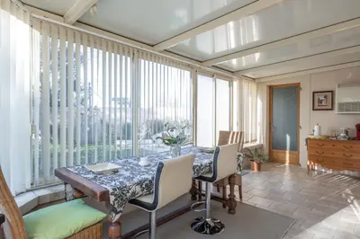 a dining room with a table and some windows at Les Lauriers en Lubéron in Cheval-Blanc