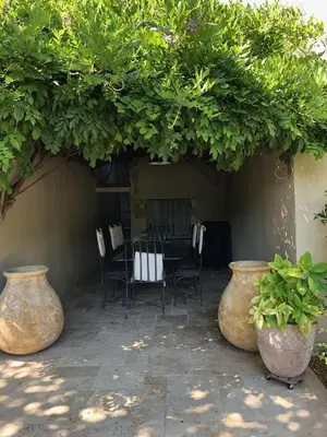 a patio with two large vases and a table and chairs at Provencal farmhouse, pool, pool house, countryside Plan d’Orgon, Provence - 8 people in Plan-dʼOrgon