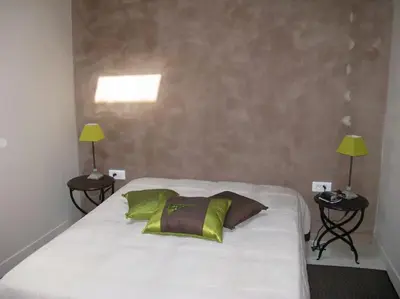 a bedroom with a large white bed with two lamps at Le Maset des Aires avec vue sur le Luberon et son jacuzzi extérieur disponible de juin à mi-septembre in Maubec