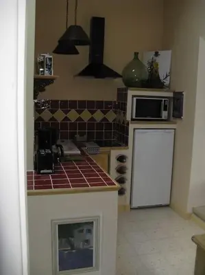 a kitchen with a microwave and a counter top at Le Maset des Aires avec vue sur le Luberon et son jacuzzi extérieur disponible de juin à mi-septembre in Maubec