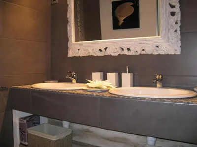a bathroom with two sinks and a mirror at Le Maset des Aires avec vue sur le Luberon et son jacuzzi extérieur disponible de juin à mi-septembre in Maubec