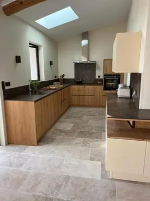 a large kitchen with wooden cabinets and a counter at La Planette in Venasque