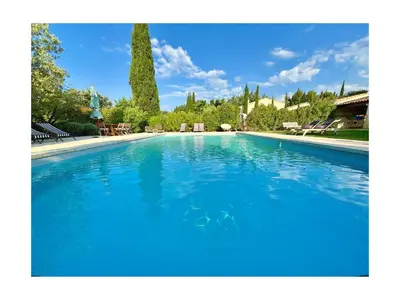a large swimming pool with blue water at Les Jardins de Sitaara in Cucuron