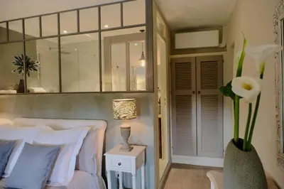 a bedroom with a white bed and a vase of flowers at Les Jardins de Sitaara in Cucuron