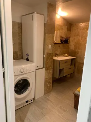 a small bathroom with a washing machine and a sink at Standing duplex FULL Equipements idéal moyen séjours in Le Thor