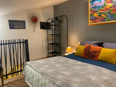 a bedroom with a bed with colorful pillows at Standing duplex FULL Equipements idéal moyen séjours in Le Thor