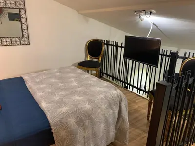 a bedroom with a bed and a flat screen tv at Standing duplex FULL Equipements idéal moyen séjours in Le Thor