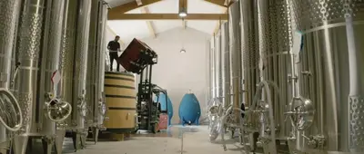 a row of wine barrels in a wine cellar at VENTOUX in Apt