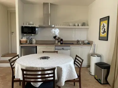 a kitchen with a table and some chairs and a kitchen with a table at VENTOUX in Apt
