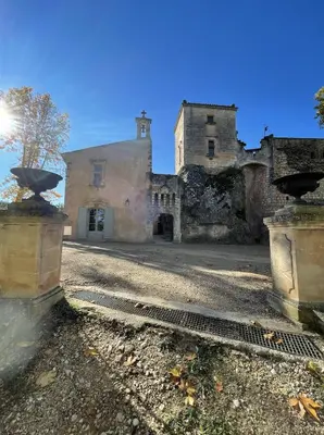 an old stone building with a tower in the background at LES ROCHES in Apt