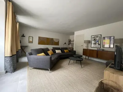 a living room with a couch and a tv at LES ROCHES in Apt
